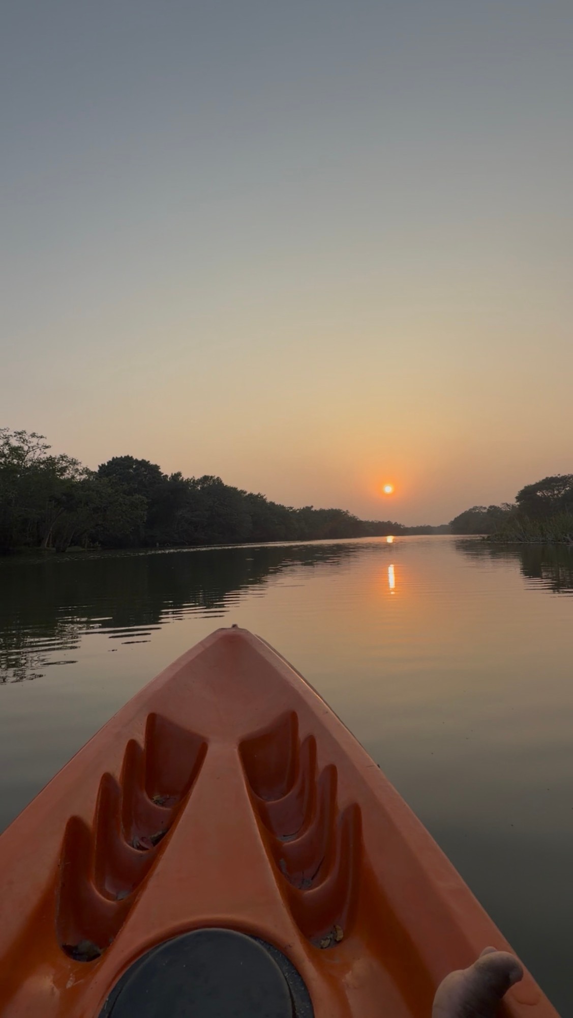 Kayak bow on still water at sunrise on the river at Wilpattu